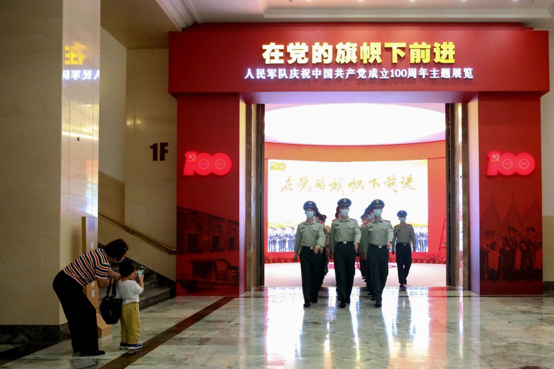一名儿童在用手机拍摄走出展厅的武警官兵。赵明摄