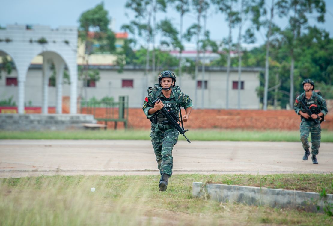 武警特战队员正在进行2公里武装越野射击训练。
